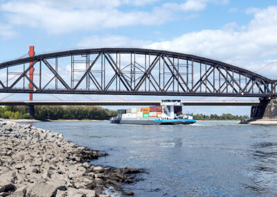 Schiff mit Containern unter einer Brücke